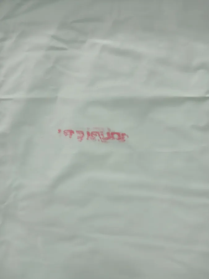 Com uma pequena marca vermelha de tinta